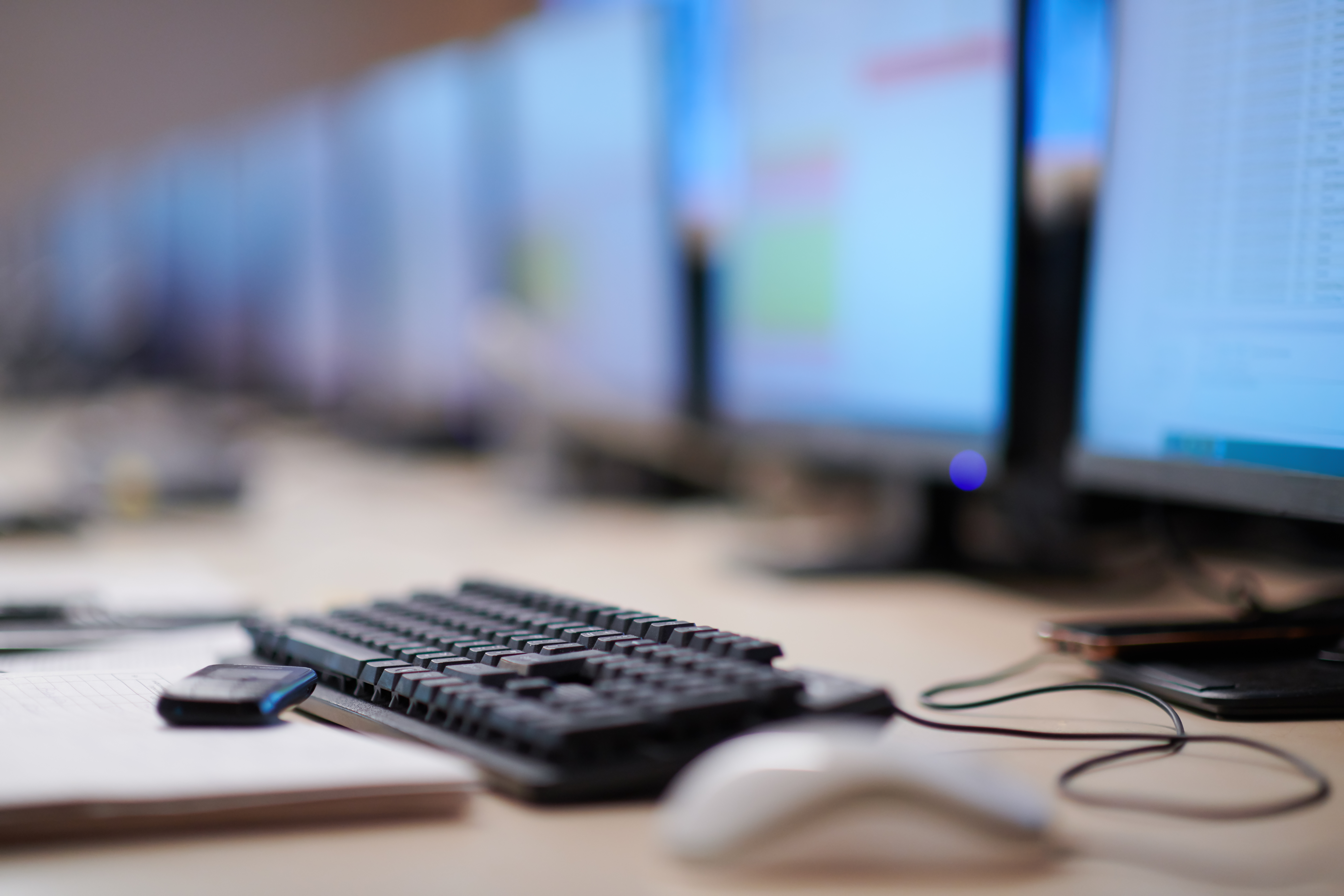 keyboard with monitors in the background
